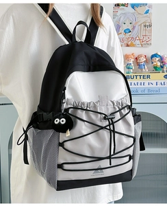 Detail of canvas backpack with bungee cords, mesh pockets and cute plush charm pendant