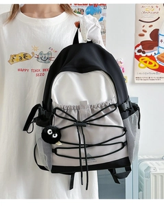 Close-up of color-block backpack with elastic bungee cords and nylon buckle details