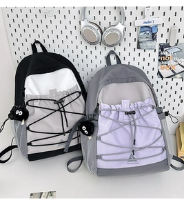 Detail of multi-color canvas backpack with front bungee cord and mesh side pockets