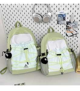 Detail of light green canvas backpack set with bungee cord and plush pendant accessories
