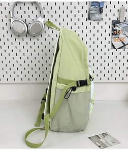 Side view of canvas backpack featuring green and white stitching with mesh pockets