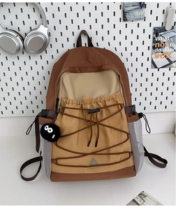 Detail of color-block canvas backpack with elastic bungee cords and mesh side pocket