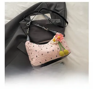 Pink pleated crossbody bag with black K print and woven floral charm accessories