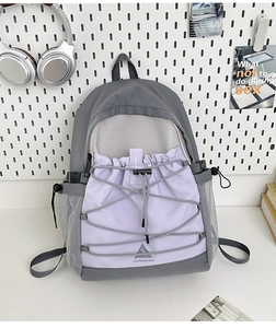 Detail view of durable nylon backpack showing color-block stitching and elastic drawstrings