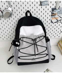 Detail of color-block canvas backpack with mesh side pockets and elastic cord system