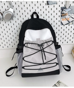 Macro detail of color-block canvas backpack featuring elastic drawstring and buckle closure