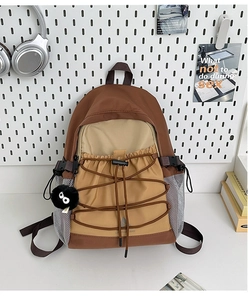 Detail of color-block canvas backpack with elastic bungee cords and mesh side pockets