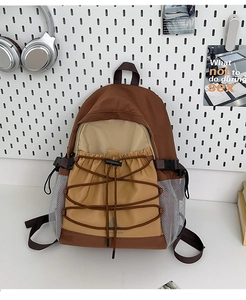 Detail of outdoor canvas backpack featuring color blocking and elastic bungee cord system