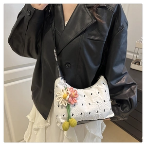 Dettaglio della borsa hobo bianca a pieghe con fiore rosa e ricamo del motivo K nero