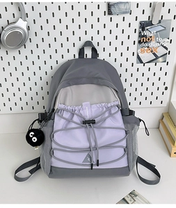 Detail of color-block canvas backpack with elastic bungee cords and mesh side pockets