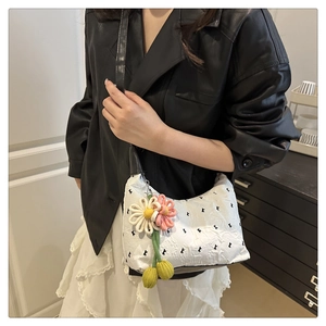 Dettaglio della borsa a spalla bianca plissettata con stampa di lettere e fiori crochet
