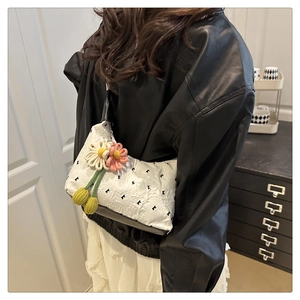 Dettaglio borsa jacquard bianca con base in pelle nera e ciondolo margherita fatto a mano