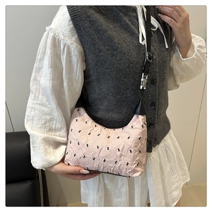 Dettaglio della borsa hobo rosa plissettata con motivi neri e tracolla in pelle