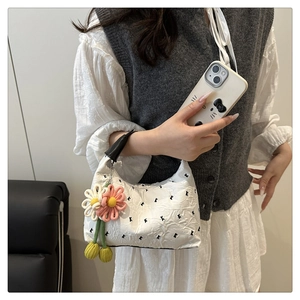 Détails du sac à main blanc plissé avec breloques florales et nœuds noirs élégants