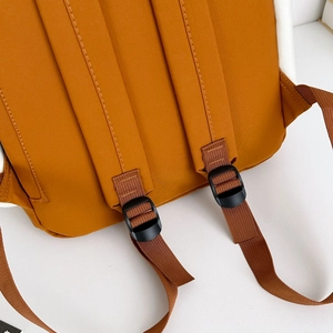 Detail of adjustable padded shoulder straps on a durable outdoor backpack in orange