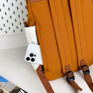 Detail of outdoor backpack rear anti-theft zipper pocket holding a smartphone