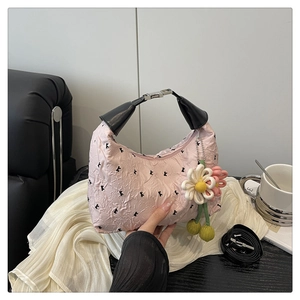 Détail du sac rose à texture bulles avec imprimé K et breloque fleur au crochet
