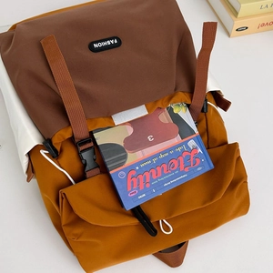 Detail view of the brown flap and ginger yellow body on the outdoor hiking backpack