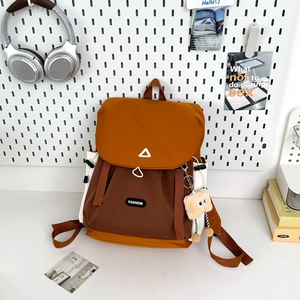 Detail view of water-resistant nylon backpack with side pocket and cute bread charm