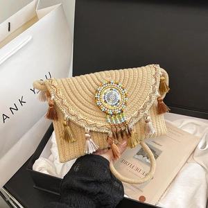 Borsa a tracolla boho intrecciata con nappe colorate e frange di perline su sfondo bianco