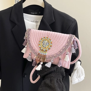 Handmade pink woven envelope bag with colorful tassels and bohemian mandala beadwork