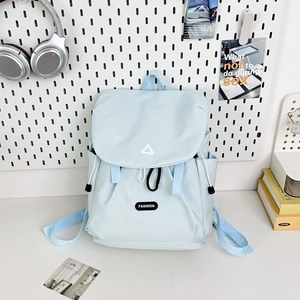 Detail of light blue nylon hiking backpack with side pocket on a white pegboard background