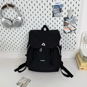 Detail of black waterproof nylon backpack with white triangle logo and drawstring closure