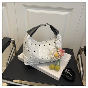 Détail d'un sac blanc à texture bulle blanc avec broderie lapin et pendentif floral coloré