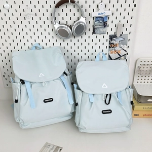 Detail of light blue waterproof nylon backpacks in large and small sizes with drawstrings