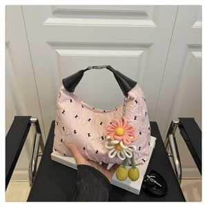 Gros plan détaillé du sac plissé rose avec breloque fleur et poignées noires