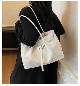 Détail du sac cabas blanc tressé avec lanières élégantes et boucle en argent massif