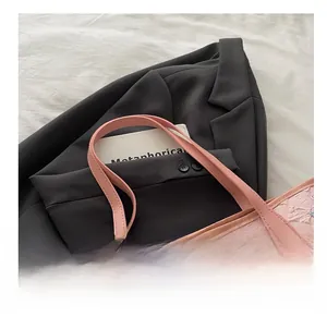 Dettaglio della borsa rosa in tela con trama a rilievo e ciondolo a nuvola morbida