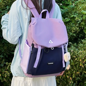 Outdoor view of a two-tone hiking backpack featuring purple and navy blue waterproof fabric