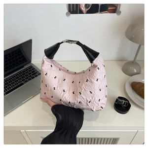 Gros plan du sac à main plissé rose avec motif de lettres et poignée en cuir noir