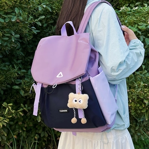 Side view of a contrast-color outdoor backpack with purple flap and navy blue base