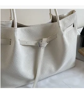 Vue détaillée du sac cabas tressé crème avec boucle métallique élégante et texture cuir