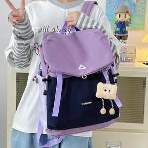 Detail of purple and navy hiking backpack with contrast colors and plush charm