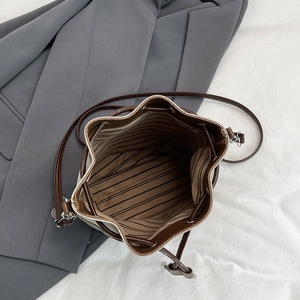 Vintage denim bucket bag with drawstring closure and striped lining in a top-down view
