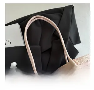 Detail of pink woven tote bag with smooth leather handles and a cute bear charm