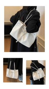 Détail du sac seau blanc tressé avec boucle en cuir élégante et texture raffinée