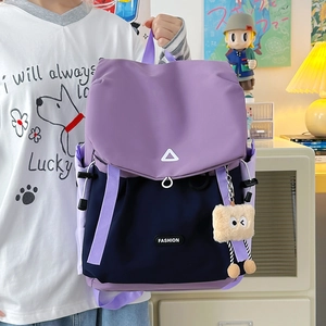 Detail of waterproof nylon backpack with purple contrast and cute plush charm