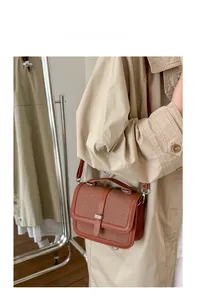 Detail of vintage brown color-block crossbody bag with buckle and adjustable strap