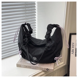 Detail of black nylon tote bag with purple decorative drawstrings and QS FASHION logo
