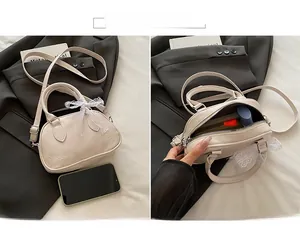 Dettaglio dello scomparto interno principale della borsa a tracolla color crema a conchiglia