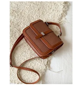 Top view of brown woven texture flap bag with silver buckle on cream plush rug