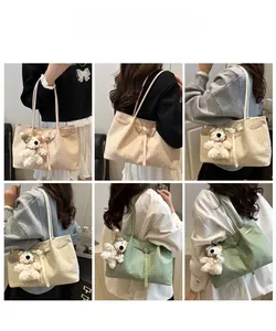 Detail showing woven texture tote bag with plush bear charm in beige and green