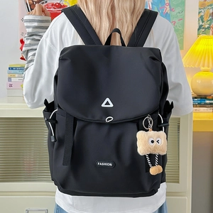 Detail of black outdoor backpack featuring drawstring closure and fashion label