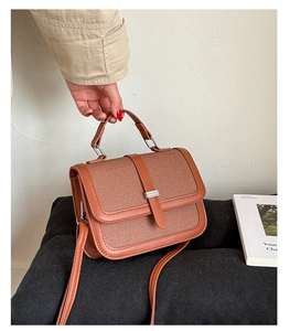 Detail of vintage brown canvas and leather crossbody bag with silver buckle and top handle