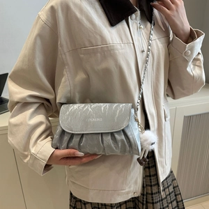Sac bandoulière plissé métallisé argent avec chaîne et breloque peluche sur modèle