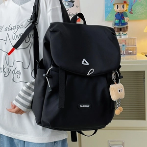 Detail of black flap backpack with white geometric lines and fashion label on a model